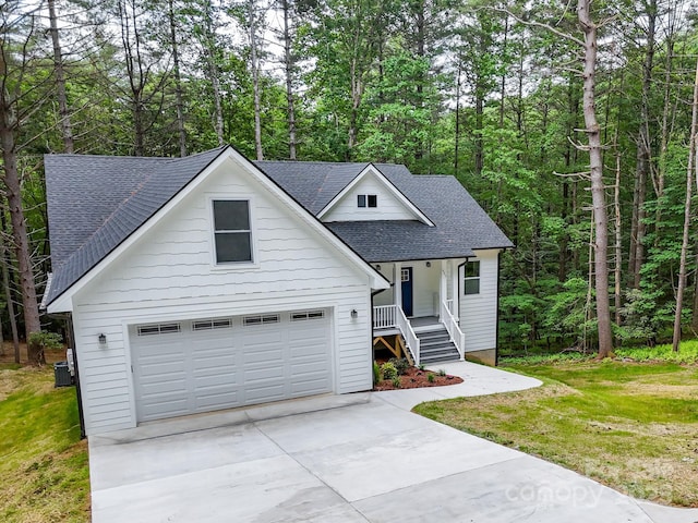 605 Knob Rd, Pisgah Forest, NC 28768 - view of front of property with roof with shingles, concrete driveway, a garage, central air condition unit, and covered porch