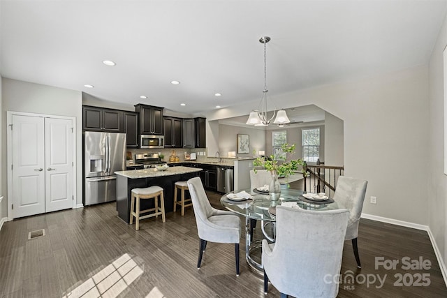 dining room featuring visible vents, baseboards, an inviting chandelier, recessed lighting, and dark wood-type flooring