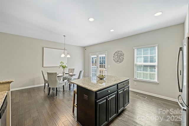 kitchen featuring dark wood finished floors, appliances with stainless steel finishes, dark cabinetry, and baseboards
