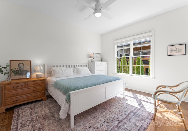bedroom with baseboards, a ceiling fan, and wood finished floors