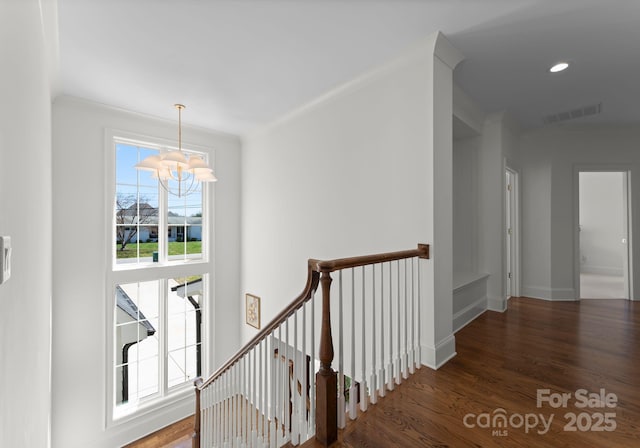 hall featuring wood finished floors, a chandelier, an upstairs landing, and visible vents