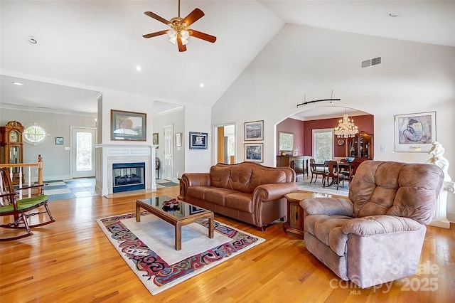 4633 River Bluff Ct, Charlotte, NC 28214 - living room with visible vents, high vaulted ceiling, arched walkways, ceiling fan with notable chandelier, and light wood-type flooring