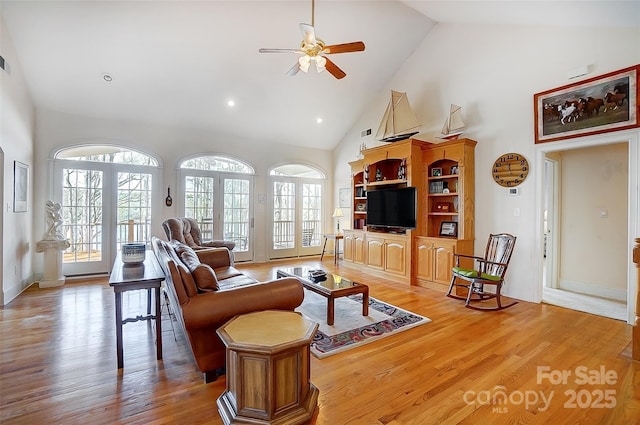 4633 River Bluff Ct, Charlotte, NC 28214 - living room with high vaulted ceiling, baseboards, light wood-style floors, and a ceiling fan