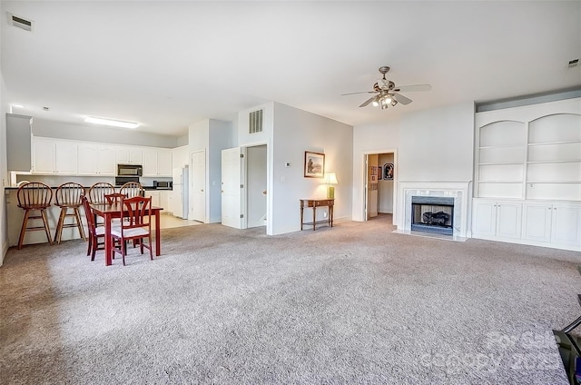 4633 River Bluff Ct, Charlotte, NC 28214 - dining room featuring light carpet, visible vents, a fireplace, and a ceiling fan