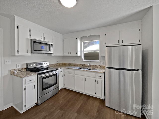 kitchen with a sink, dark wood-style floors, white cabinetry, and stainless steel appliances