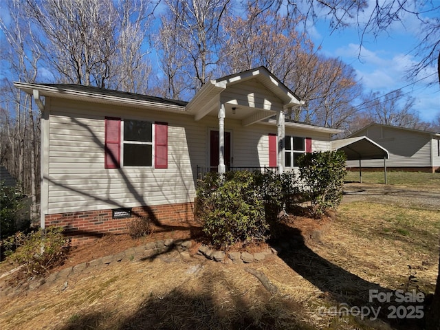 view of side of property featuring a detached carport and crawl space