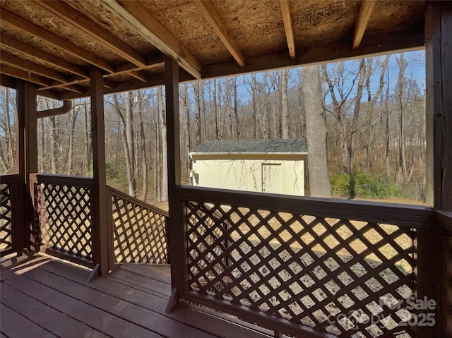 wooden deck with a storage unit and an outdoor structure