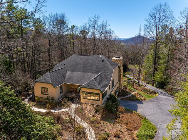 birds eye view of property featuring a mountain view and a view of trees