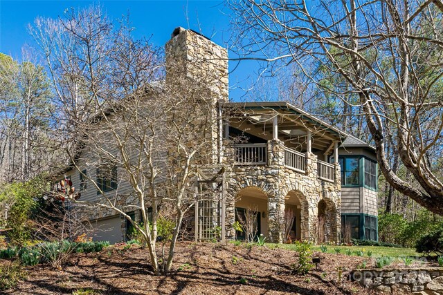 view of front of property featuring a balcony and a chimney
