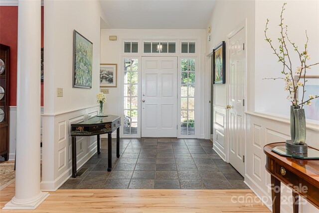 foyer with stone tile flooring and ornate columns