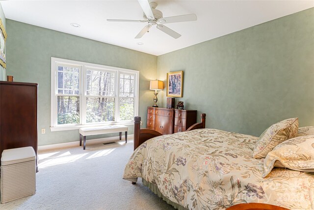 carpeted bedroom with baseboards and a ceiling fan