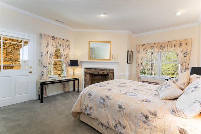 bedroom featuring a stone fireplace, visible vents, ornamental molding, and carpet