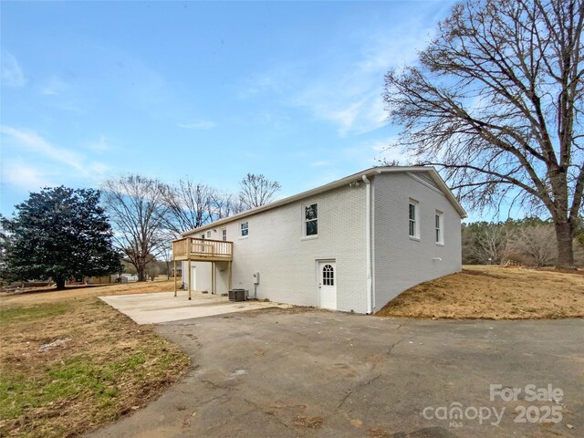 510 Newport Dr, Salisbury, NC 28144 - back of property with a wooden deck, brick siding, central AC, and a patio area