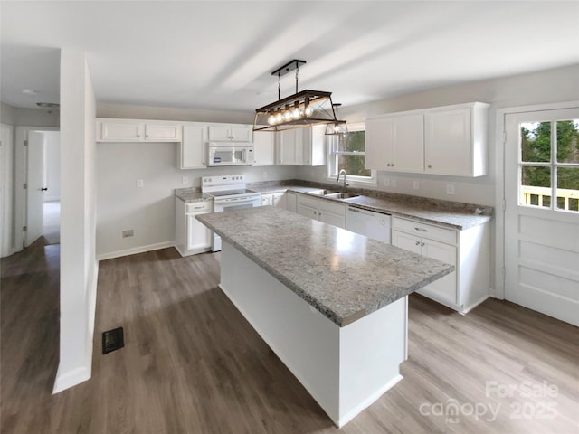 510 Newport Dr, Salisbury, NC 28144 - kitchen featuring white appliances, wood finished floors, hanging light fixtures, white cabinetry, and a center island
