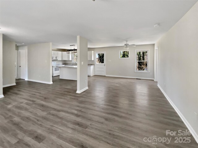 510 Newport Dr, Salisbury, NC 28144 - unfurnished living room featuring dark wood-style floors, ceiling fan with notable chandelier, and baseboards