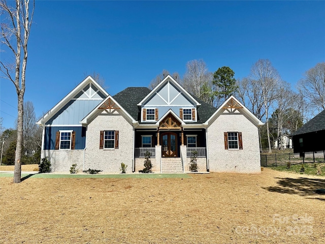 view of front of home featuring a porch, fence, french doors, board and batten siding, and brick siding