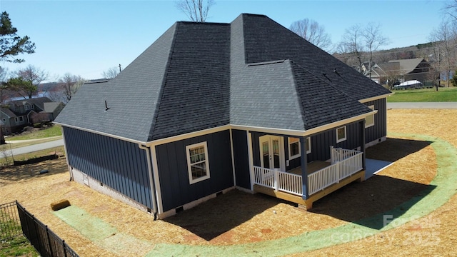 exterior space featuring a porch, roof with shingles, and board and batten siding