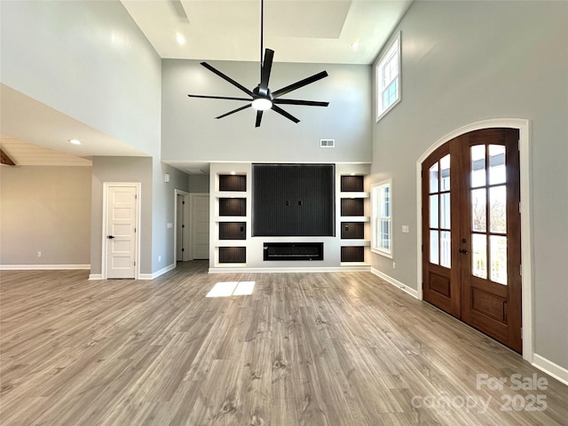 entrance foyer with visible vents, baseboards, french doors, light wood-style floors, and a ceiling fan