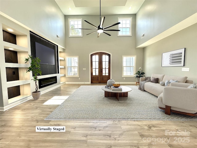 living room with wood finished floors, baseboards, a wealth of natural light, and ceiling fan