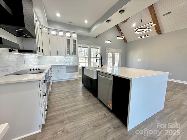 kitchen featuring a sink, backsplash, stainless steel dishwasher, wall chimney exhaust hood, and black electric stovetop
