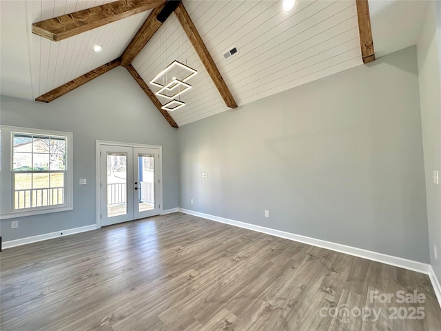 spare room featuring baseboards, beamed ceiling, french doors, wood finished floors, and high vaulted ceiling