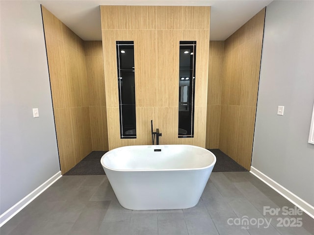 full bathroom featuring tile patterned flooring, a walk in shower, and a freestanding bath