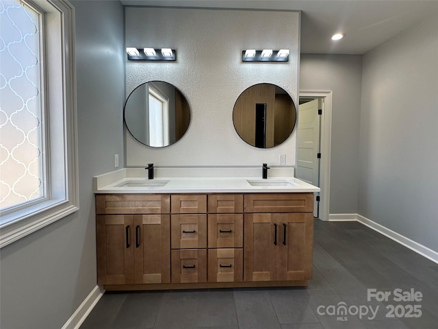 full bath featuring a sink, baseboards, and tile patterned floors