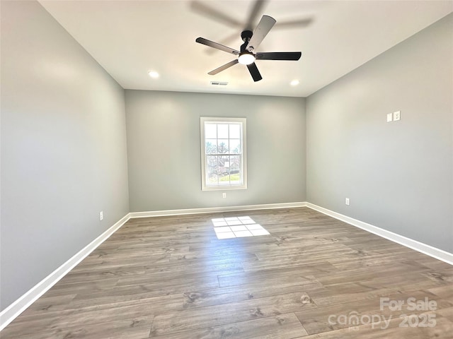 empty room featuring visible vents, baseboards, wood finished floors, and a ceiling fan