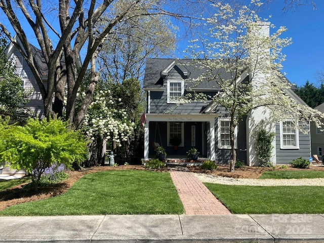 cape cod-style house with a front yard