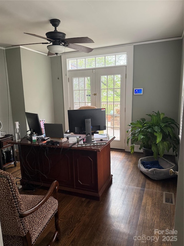 office space with dark wood-type flooring, ceiling fan, visible vents, and crown molding