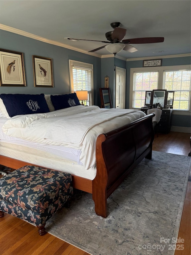 bedroom featuring a ceiling fan, crown molding, and wood finished floors
