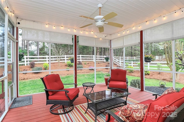sunroom / solarium with rail lighting and a ceiling fan