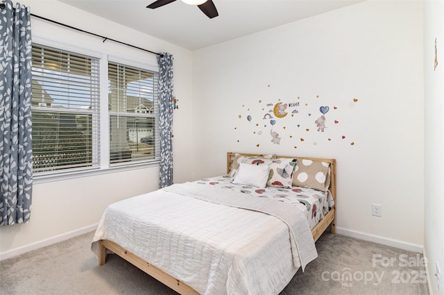 carpeted bedroom featuring baseboards and a ceiling fan