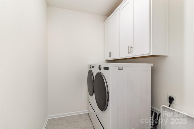laundry area with baseboards, cabinet space, and washing machine and dryer