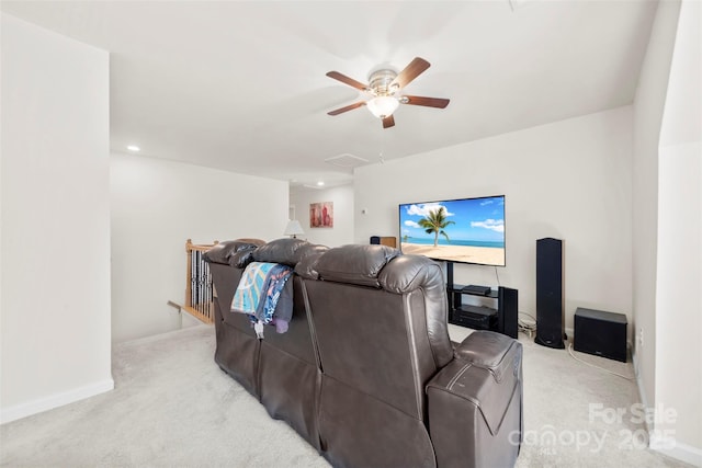 cinema room featuring light colored carpet, baseboards, and a ceiling fan