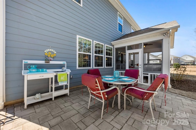 view of patio / terrace with outdoor dining space and a sunroom