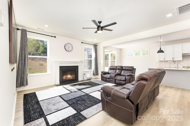 165 Winterberry St, Mooresville, NC 28117 - living room with light wood-style floors, visible vents, a ceiling fan, and a healthy amount of sunlight