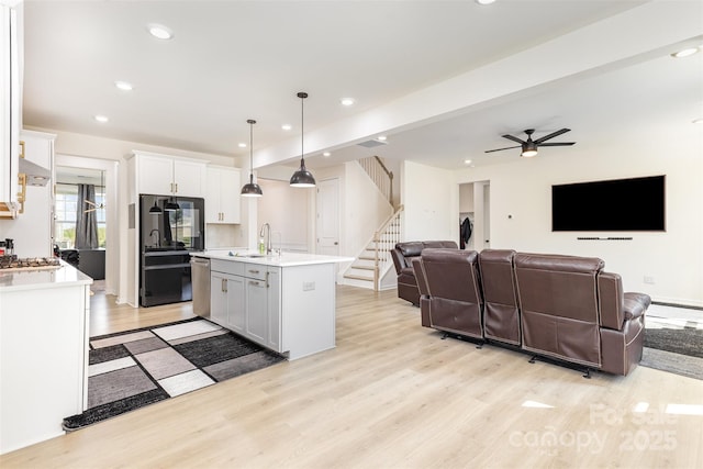 165 Winterberry St, Mooresville, NC 28117 - kitchen featuring a sink, light countertops, appliances with stainless steel finishes, light wood-type flooring, and white cabinetry