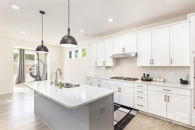 165 Winterberry St, Mooresville, NC 28117 - kitchen with under cabinet range hood, light countertops, a sink, and decorative backsplash