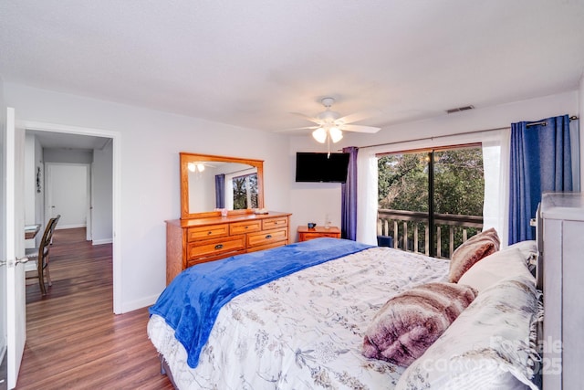 bedroom featuring access to exterior, visible vents, ceiling fan, baseboards, and wood finished floors