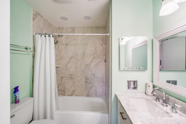 bathroom with vanity, toilet, shower / bath combo with shower curtain, and a textured ceiling