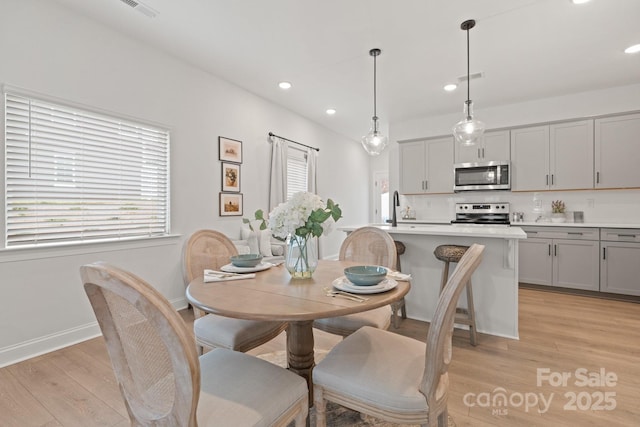 dining room with recessed lighting, light wood-type flooring, baseboards, and visible vents