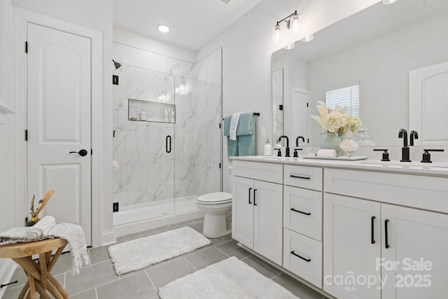 full bathroom featuring double vanity, toilet, a marble finish shower, and a sink