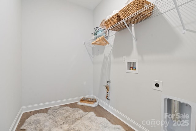 clothes washing area with hookup for a washing machine, wood finished floors, baseboards, hookup for an electric dryer, and laundry area