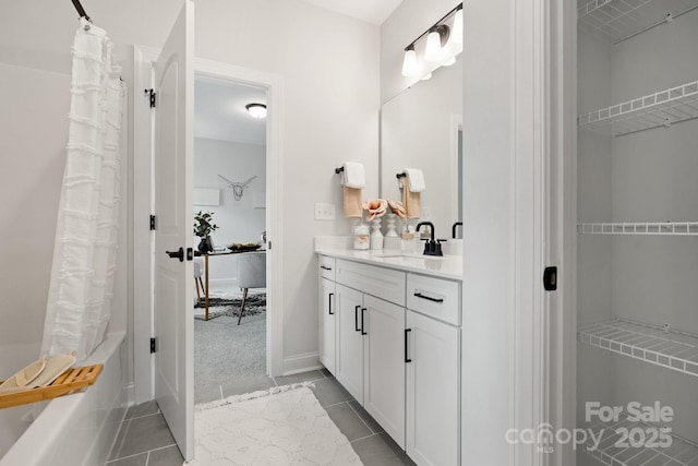 bathroom featuring tile patterned floors, a spacious closet, shower / bath combo, and vanity