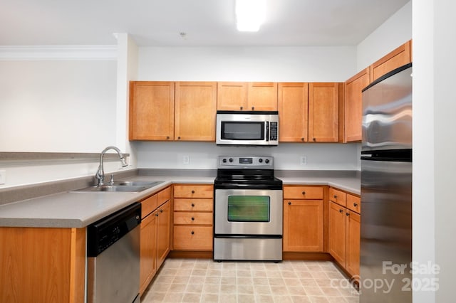 kitchen featuring a sink, ornamental molding, light countertops, stainless steel appliances, and brown cabinets
