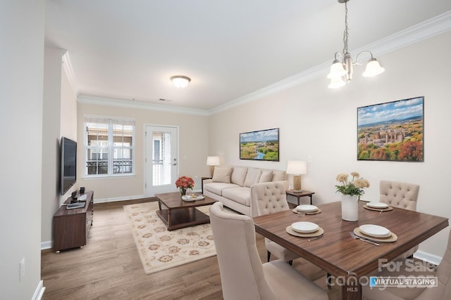 dining area with a notable chandelier, wood finished floors, baseboards, and ornamental molding