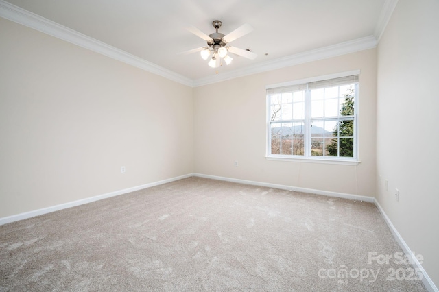 carpeted empty room featuring crown molding, a ceiling fan, and baseboards
