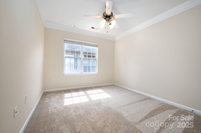 carpeted spare room with visible vents, baseboards, ceiling fan, and ornamental molding
