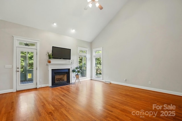 8008 Battersea Ct, Waxhaw, NC 28173 - unfurnished living room with ceiling fan, a fireplace, high vaulted ceiling, baseboards, and light wood-style flooring